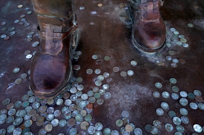 Pennies collected on the bottom of the George P. Mitchell statue. Sunset at Texas A&M University at Galveston in Galveston, Texas, on July 27, 2022. (Laura McKenzie/Texas A&M University Division of Marketing & Communications)